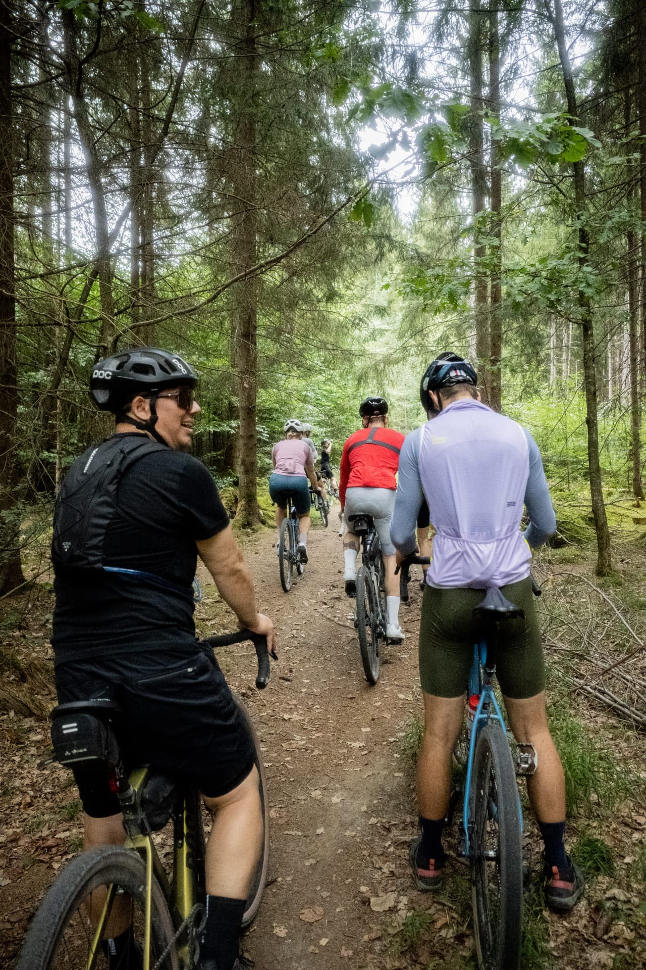 Gruppe fährt auf einem schmalen Waldpfad